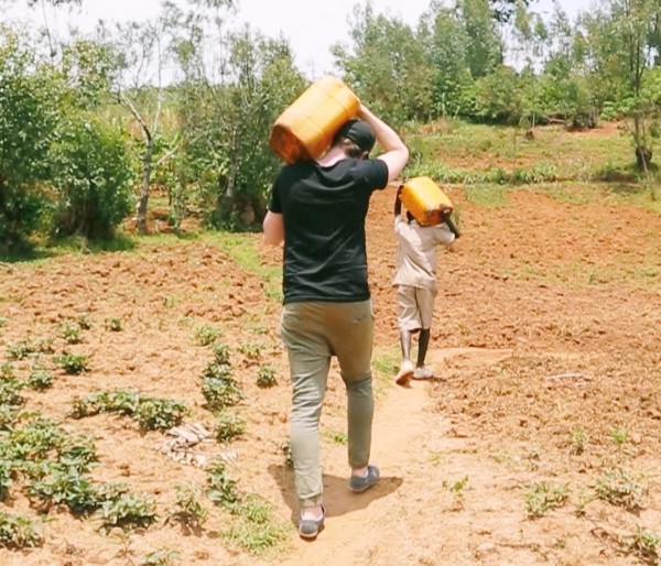 Our co-founder Daniel learning about Vianney’s water walk when we visited our water project in Burundi